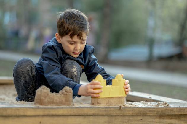 Boy building sandcastle with toy at park model released, Symbolfoto, ANAF01380