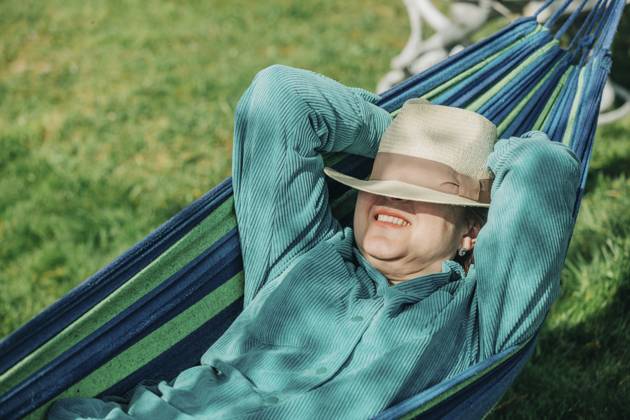 Senior woman with hands behind head relaxing on hammock at sunny day model released, Symbolfoto, VSNF00786