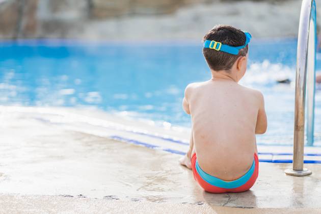 MR_ID14021_13417_EtxahunUnzueta.jpg Back view of unrecognizable kid with swimming goggles on his head sitting with his hands together on folded legs as he stares into the pool, Model released HodeiUnzueta_ID14021_423070_035 Copyright: xHodeixUnzuetax MR