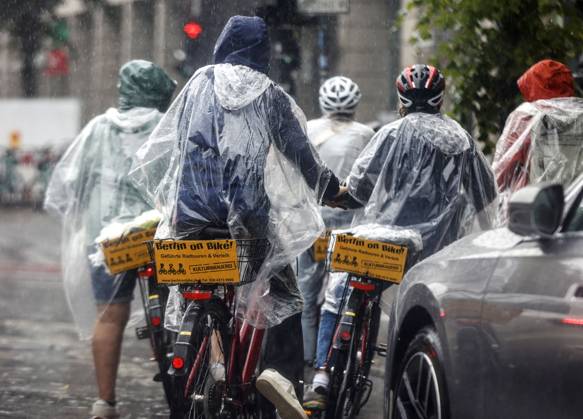 Rainy weather Berlin, 23 06 2023 Tourists of a Berlin On Bike bicycle tour protect themselves with rain capes from heavy rainfall Heavy thunderstorms have moved over parts of Germany Berlin Berlin Germany