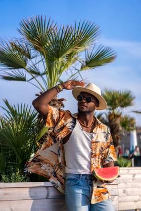 A shallow focus of a young handsome black man eating fresh watermelon at the beach *** einer seicht Fokus des einer Jung gutaussehenden Schwarz Mann essender Frisch Wassermelone im der Strand 19751168 ,model released, Symbolfoto RECORD DATE NOT STATED