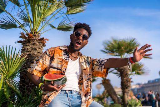 A shallow focus of a young handsome black man eating fresh watermelon at the beach *** einer seicht Fokus des einer Jung gutaussehenden Schwarz Mann essender Frisch Wassermelone im der Strand 19751174 ,model released, Symbolfoto RECORD DATE NOT STATED