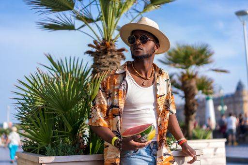 A shallow focus of a young handsome black man eating fresh watermelon at the beach *** einer seicht Fokus des einer Jung gutaussehenden Schwarz Mann essender Frisch Wassermelone im der Strand 19751180 ,model released, Symbolfoto RECORD DATE NOT STATED