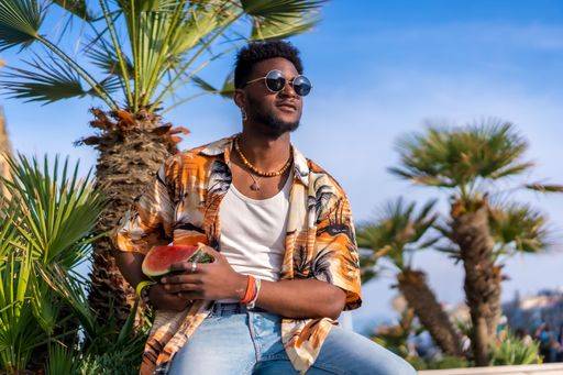 A shallow focus of a young handsome black man eating fresh watermelon at the beach *** einer seicht Fokus des einer Jung gutaussehenden Schwarz Mann essender Frisch Wassermelone im der Strand 19751196 ,model released, Symbolfoto RECORD DATE NOT STATED