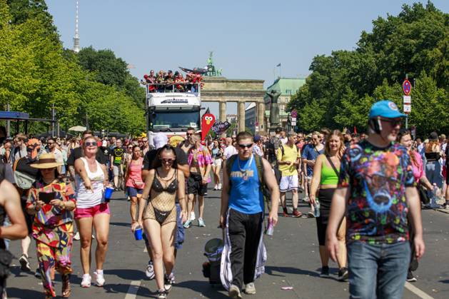 Rave the Planet 2023 Germany, Berlin on 08 July 2023 about 200 000 ravers and techno fans parade through the Tiergarten on the Starsse des 17 Juni on a hot summer day A young woman holds up a homemade sign that reads Love is the Answer