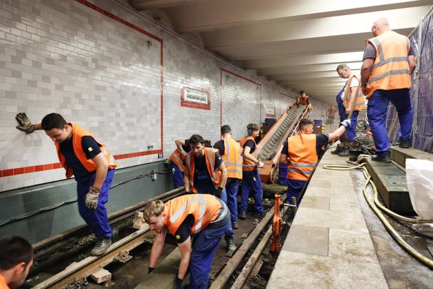 10 07 2023, Berlin Germany At the Alexanderplatz underground station, construction work is underway on the U2 track, which has been closed due to an accident Holes are drilled for planks, the straight line is measured and then the screws are tightened.