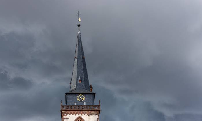 Dark clouds over the church tower Dark clouds of a thunderstorm are seen in the afternoon in the sky above the tower of the Catholic Church St Ursula , Oberursel Hesse Germany