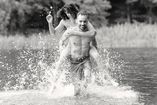 CREATIVE - Paar am See in Berlin Berlin, Deutschland - 25. Juli 2023: (CREATIVE) Ein Mann trägt Huckepack eine Frau (Models) und genießen einen Sommertag an der Krummen Lanke, einem See in Berlin. Berlin