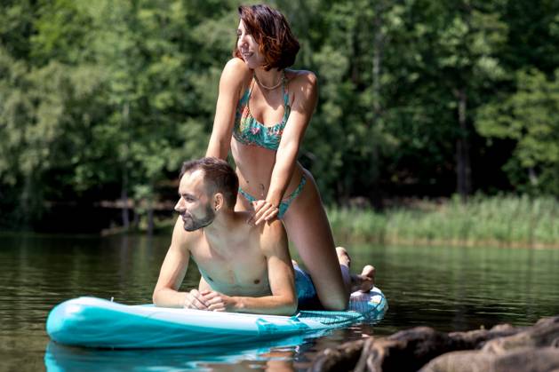 CREATIVE - Paar am See in Berlin Berlin, Deutschland - 25. Juli 2023: (CREATIVE) Ein Mann und eine Frau (Models) genießen auf einem SUP (stand up paddle boat) einen Sommertag an der Krummen Lanke, einem See in Berlin. Berlin