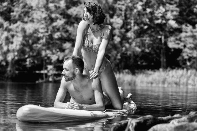 CREATIVE - Paar am See in Berlin Berlin, Deutschland - 25. Juli 2023: (CREATIVE) Ein Mann und eine Frau (Models) genießen auf einem SUP (stand up paddle boat) einen Sommertag an der Krummen Lanke, einem See in Berlin. Berlin
