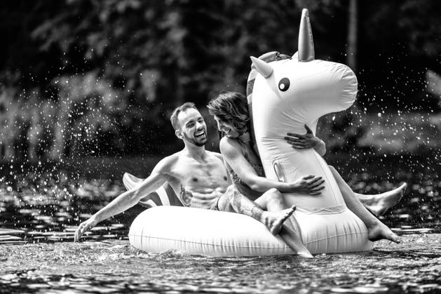 CREATIVE - Paar am See in Berlin Berlin, Deutschland - 25. Juli 2023: (CREATIVE) Ein Mann und eine Frau (Models) genießen auf einem aufgeblasenen Einhorn einen Sommertag an der Krummen Lanke, einem See in Berlin. Berlin