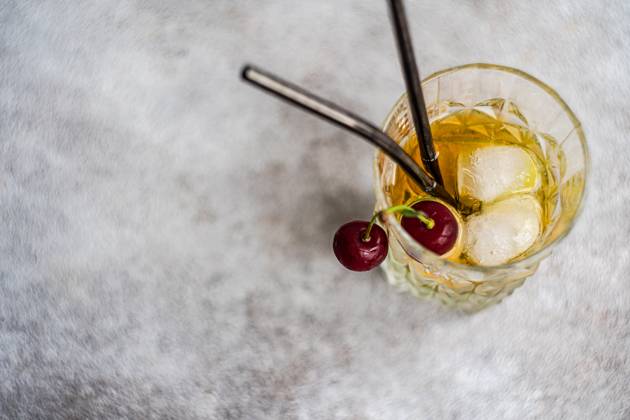 Glass of cold refreshing summer drink with cherry placed on gray surface against light background during summer celebration MR AnnaBogush_ID15448_470079_009 Copyright: xAnnaxBogushx Model Released