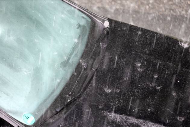 Dangerous road conditions during heavy rain Heavy rain pelts a car and the suddenly fogged window takes away all visibility