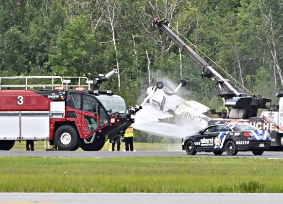 August 1, 2023, QUEBEC, PQ, Canada: Firefighters spray down a Cessna 152 aircraft as it is towed away after it crashed on landing at the Jean-Lesage Airport in Quebec City, Tuesday, Aug. 1, 2023. One person was reported injured. QUEBEC Canada  - ZUMAc35_ 20230801_zaf_c35_022 Copyright: xJacquesxBoissinotx