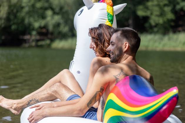 CREATIVE - Paar am See in Berlin Berlin, Deutschland - 25. Juli 2023: (CREATIVE) Ein Mann und eine Frau (Models) genießen auf einem aufgeblasenen Einhorn einen Sommertag an der Krummen Lanke, einem See in Berlin. Berlin