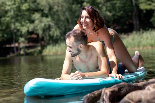 CREATIVE - Paar am See in Berlin Berlin, Deutschland - 25. Juli 2023: (CREATIVE) Ein Mann und eine Frau (Models) genießen auf einem SUP (stand up paddle boat) einen Sommertag an der Krummen Lanke, einem See in Berlin. Berlin