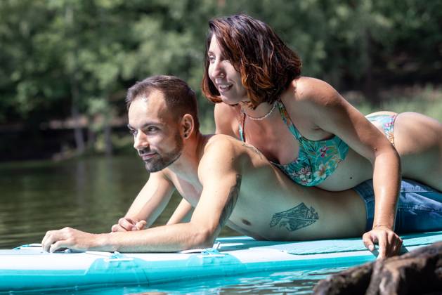 CREATIVE - Paar am See in Berlin Berlin, Deutschland - 25. Juli 2023: (CREATIVE) Ein Mann und eine Frau (Models) genießen auf einem SUP (stand up paddle boat) einen Sommertag an der Krummen Lanke, einem See in Berlin. Berlin