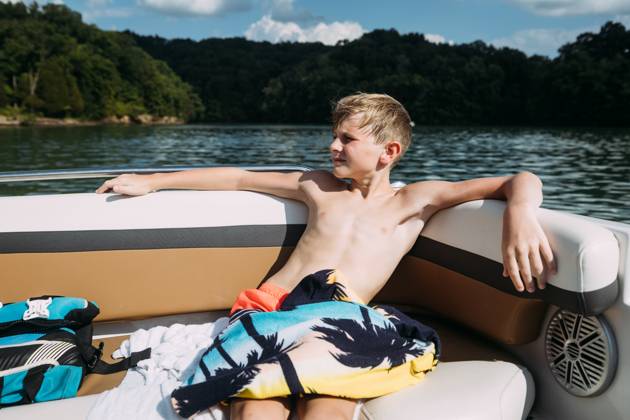 IMAGO Creative, Jahreszeit Sommer, Sommerferien Young boy sitting on pontoon boat during summer on sunny day on Cookeville, Tennessee, United States CR_WEKW23082878-1242356-01 ,model released, Symbolfoto