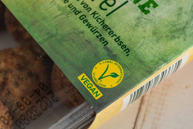 Augsburg, Bavaria, Germany - 29 August 2023: The V Label (European Vegetarian Union) on a package of vegan falafel. Vegan Food Label