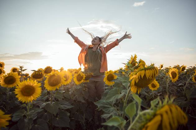 Happy woman with arms outstretched standing in sunflower field model released, Symbolfoto property released, ADF00144