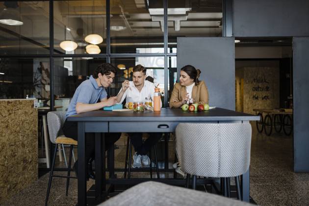 Colleagues having food sitting at table in office model released, Symbolfoto property released, DCRF01777