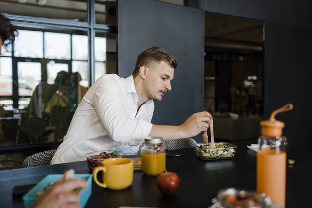 Businessman eating food from container at office model released, Symbolfoto property released, DCRF01778
