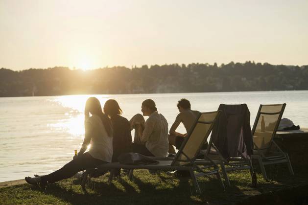 Group of young friends partying at lakeside during sunset, Bavaria, Germany Bavaria, Germany, Europe CR_RONI150802-00205-01 ,model released, Symbolfoto