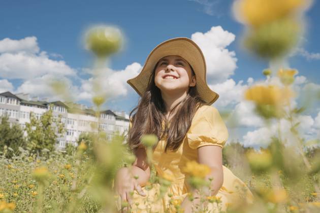 Contemplative girl wearing hat in flower field on sunny day model released, Symbolfoto, OSF01975