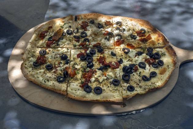 Flambé with dried Tomatoes, Sheeps cheese, Olives and Chives at a Wooden board served, Bavaria, Germany, Europe Copyright: imageBROKER HelmutxMeyerxzurxCapellen iblmzc09837998.jpg