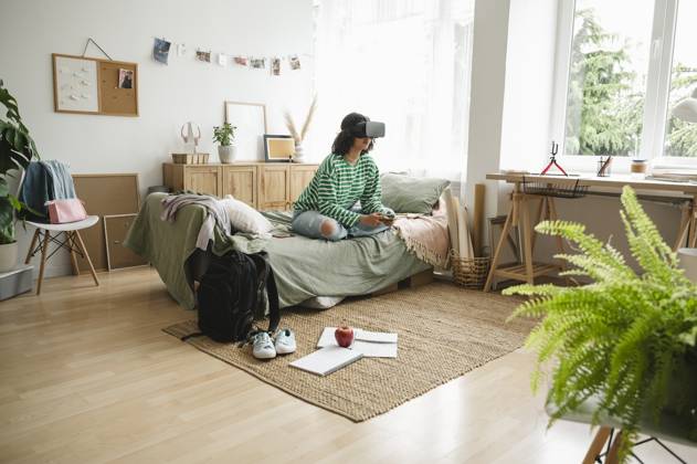 IMAGO Creative, Lifestyle, Gaming Teenage girl wearing virtual reality simulators playing video game with controller at home model released, Symbolfoto property released, ALKF00664