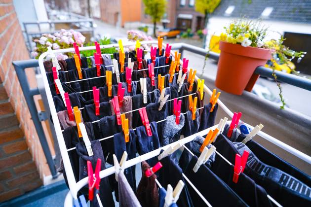 Düsseldorf 28 11 2023 clothes horse colorful clothesline clothespins sustainable environmentally friendly drying wet laundry in the air balcony solar energy wind energy sunlight solar heat solar heat save electricity no tumble dryer electricity consumption washing clothes socks flower pot Düsseldorf North Rhine-Westphalia Germany