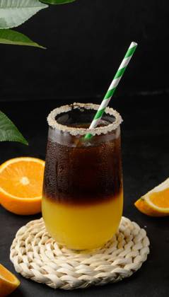 Iced coffee with orange juice in a transparent glass, refreshing bumble coffee on the table, black background Iced coffee with orange juice in a transparent glass, refreshing bumble coffee on the table, black background Copyright: xZoonar.com DANKOxNx 20484240