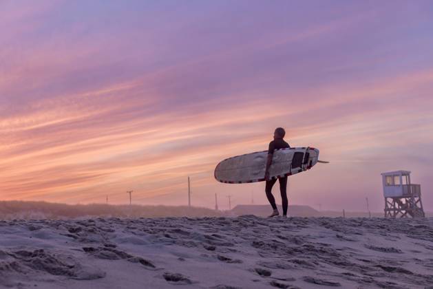 A surfer walks on the beach with his surfboard at sunset Orleans, Massachusetts, United States CR_JUCU231129F1-1272598-01 ,model released, Symbolfoto