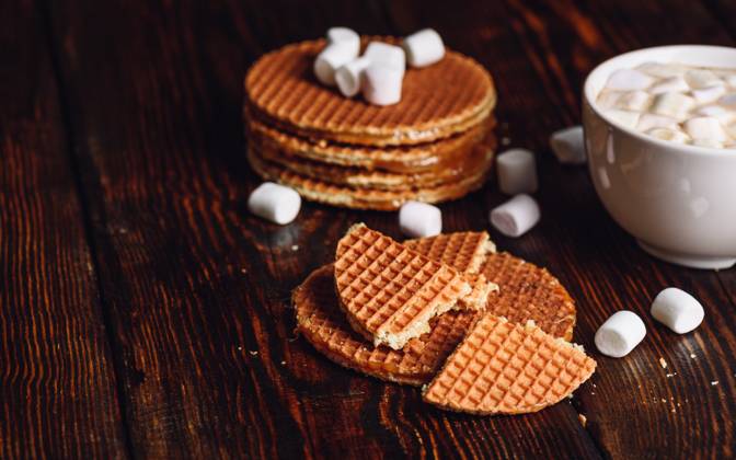 Syrup Waffles and Hot Cocoa with Marshmallow. Syrup Waffles with Broken One with White Cup of Cocoa with Marshmallow and Waffle Stack. Copy Space on the Left. Copyright: xZoonar.com VsevolodxBelousovx 13495353