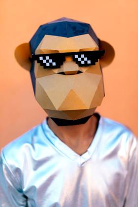 IMAGO Creative, Gesellschaft, Fasching Creative Highlights Symbolbilder Unrecognizable man in monkey mask standing against orange backdrop Anonymous male in silver V neck shirt and monkey mask with pixel party sunglasses looking at camera while standing against orange background in light Model Released SergioVictorVega_ID17382_528473_020 Copyright: xSergioxVictorxVegax