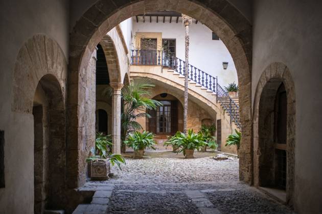 Spain Balearic islands Mallorca Palma de Mallorca Carrer de Can Savella stret Interior of some of the Majorcan patios Mallorca courtyard. Majorcan-style interior patios of some houses on Calle Can Savella. Can Vivot, declared an Asset of Cultural Interest and a Historic-Artistic Monument, has a spectacular stately courtyard populated by three vintage horse-drawn carriages. Behind this impressive entrance hides a no less surprising origin that dates back to the fourteenth century with the union of the raconada d en Berard and l alberg d en ClapÃ s, houses very close to each other. Prior to that, there is an Arab arch that, according to Montaner, is believed to be the roof of some baths. Mallorca Baleares Spain Copyright: xSergixReboredox xVWPicsx SRE-FY0061