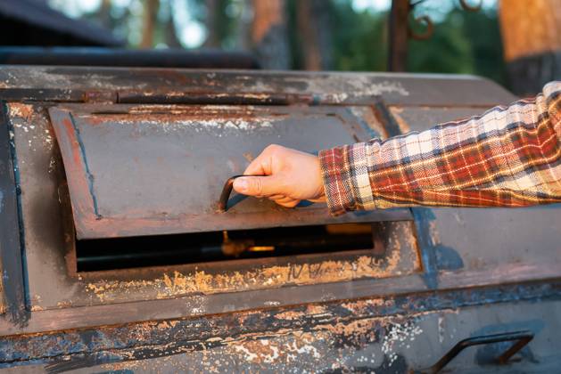 A man in a frilly shirt is looking at an excellent professional grill for re-frying meat. Professional outdoor BBQ. A man in a frilly shirt is looking at an excellent professional grill for re-frying meat. Professional outdoor BBQ Copyright: xZoonar.com SergiyxArtsabax 19513671