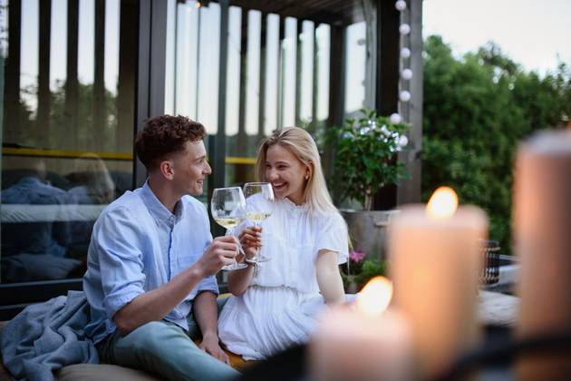 Young couple clinking with wine outdoors, weekend away in tiny house in countryside, sustainable living. A young couple clinking with wine outdoors, weekend away in tiny house in countryside, sustainable living. model released Copyright: xx HHH TINY HOUSE LIVING 2022 HHH 512