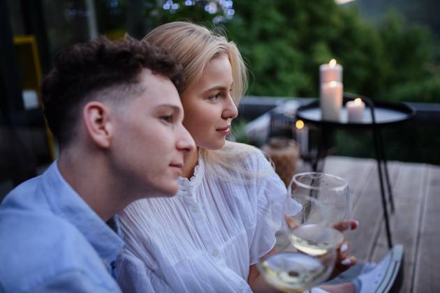 Young couple clinking with wine outdoors, weekend away in tiny house in countryside, sustainable living. A young couple clinking with wine outdoors, weekend away in tiny house in countryside, sustainable living. model released Copyright: xx HHH TINY HOUSE LIVING 2022 HHH 520