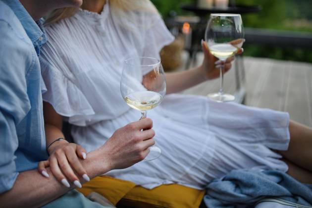 Young couple clinking with wine outdoors, weekend away in tiny house in countryside, sustainable living. Close-up. A young couple clinking with wine outdoors, weekend away in tiny house in countryside, sustainable living. Close-up. model released Copyright: xx HHH TINY HOUSE LIVING 2022 HHH 526