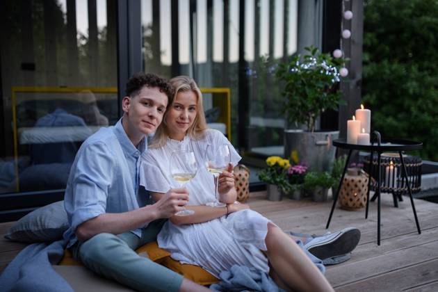 Young couple clinking with wine outdoors, weekend away in tiny house in countryside, sustainable living. A young couple clinking with wine outdoors, weekend away in tiny house in countryside, sustainable living. model released Copyright: xx HHH TINY HOUSE LIVING 2022 HHH 530