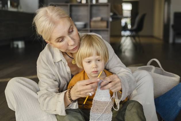 Mature woman teaching grandson to knit at home model released, Symbolfoto property released, SEAF02069