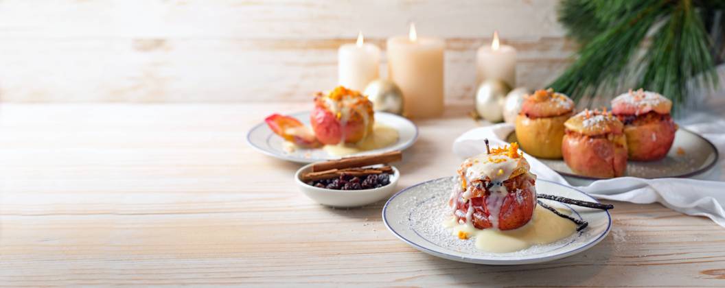 German baked apples wit powdered sugar and vanilla sauce, stuffed with almonds, honey and rosins on a light wooden background, Christmas time dessert, panoramic format, copy space German baked apples wit powdered sugar and vanilla sauce, stuffed with almonds, honey and rosins on a light wooden background, Christmas time dessert, panoramic format, copy space, selected focus Copyright: xZoonar.com MarenxWinterx 20987783
