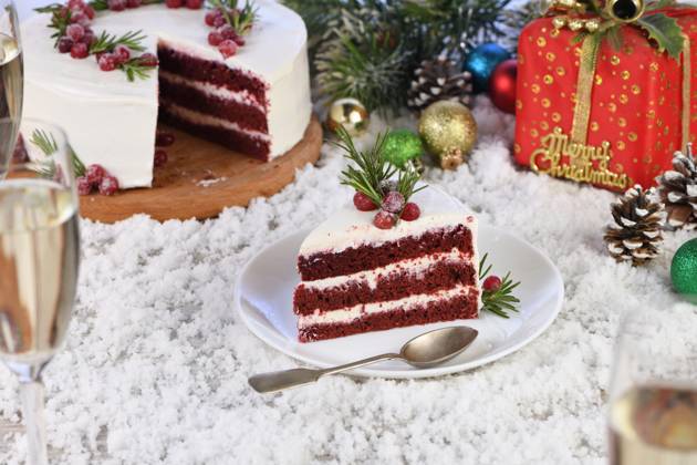 Piece of Red Velvet Cake Red Velvet Cake is a traditional red chocolate cake topped with white buttercream and decorated with a Christmas wreath of candied cranberries and rosemary. Copyright: xZoonar.com MarynaxVoronovax 21069440