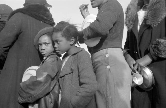 African Americans in the lineup for food at mealtime in the camp for flood refugees at Forrest City, Arkansas, 1937 (b w photo) 3666438 African Americans in the lineup for food at mealtime in the camp for flood refugees at Forrest City, Arkansas, 1937 (b w photo) by Evans, Walker (1903-75); Private Collection; (add.info.: Photograph taken for the U.S. Resettlement Administration: a New Deal U.S. federal agency that, between April 1935 and December 1936, relocated struggling urban and rural families to communities planned by the federal government.). Copyright: xBridgemanxImagesx 3666438