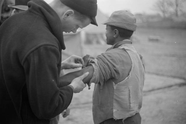 Vaccination in the camp for Negro flood refugees at Marianna, Arkansas 3666441 Vaccination in the camp for Negro flood refugees at Marianna, Arkansas by Evans, Walker (1903-75); Private Collection; (add.info.: Photograph taken for the U.S. Resettlement Administration: a New Deal U.S. federal agency that, between April 1935 and December 1936, relocated struggling urban and rural families to communities planned by the federal government.). Copyright: xBridgemanxImagesx 3666441