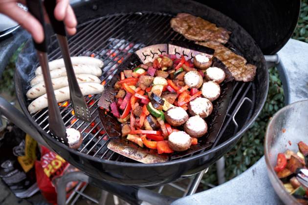 Barbecue at a Round grill become simultaneously Sausages, Steaks and Vegetables grilled Food NRW
