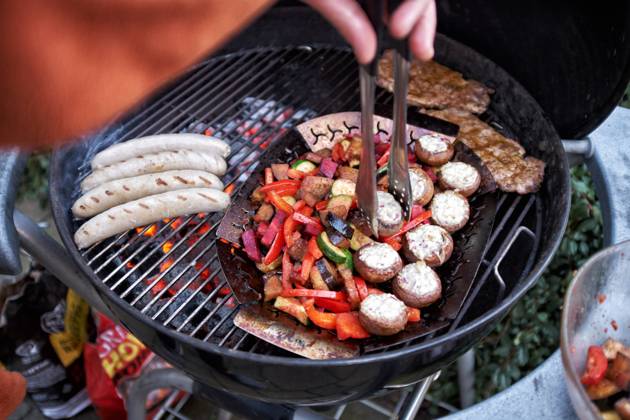 Barbecue at a Round grill become simultaneously Sausages, Steaks and Vegetables grilled Food NRW