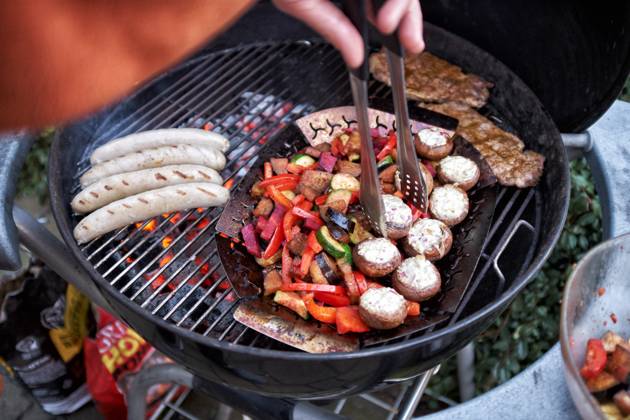 Barbecue at a Round grill become simultaneously Sausages, Steaks and Vegetables grilled Food NRW