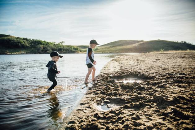 Side view of two young boys playing in a lake on a summer evening. Bismarck, North Dakota, United States CR_KIFR240228-1358305-01 ,model released, Symbolfoto